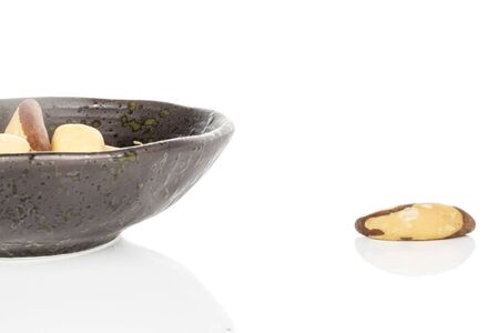Lot of whole brazil brown nut in glazed bowl isolated on white backgroundの写真素材