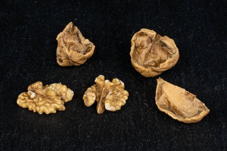 Group of two halves three pieces of tasty brown walnut on grey stoneの写真素材