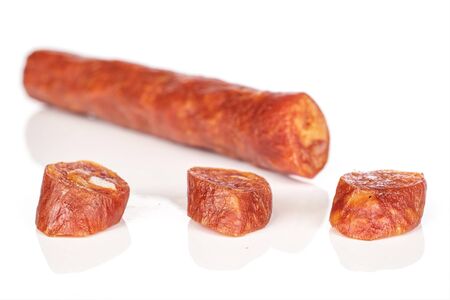 Group of one half three slices of piquant smoked sausage isolated on white backgroundの写真素材