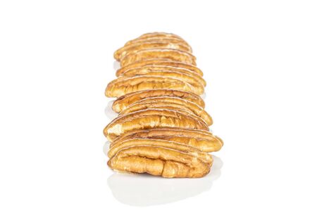 Lot of whole tasty brown pecan half in row isolated on white background