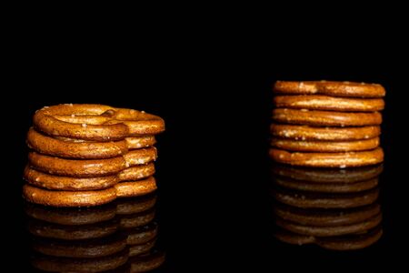 Group of ten whole salty brown pretzel isolated on black glassの写真素材