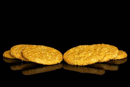 Group of six whole sweet golden oat cookie isolated on black glassの写真素材