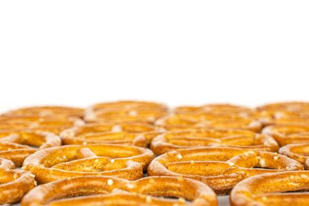 Lot of whole salty brown pretzel in closeup isolated on white background
