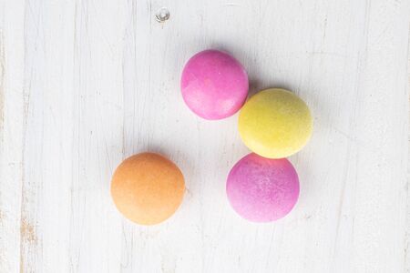 Group of four whole sweet colourful candy flatlay on white wood