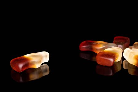 Group of six whole arranged sweet jelly cola isolated on black glassの写真素材