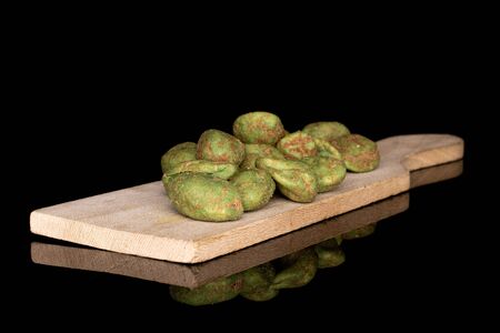 Lot of whole wasabi green peanut on wooden cutting board isolated on black glassの写真素材