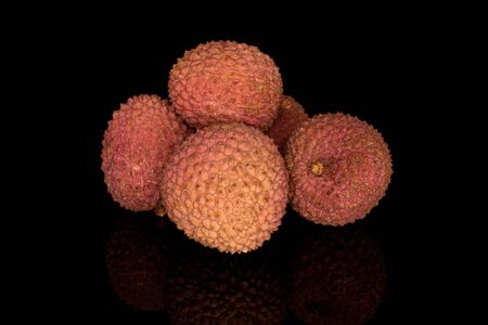 Group of five whole fresh lychee isolated on black glassの写真素材