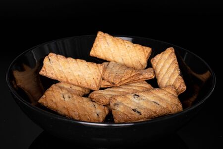 Lot of whole square puff cookie with raisins isolated on black glassの写真素材