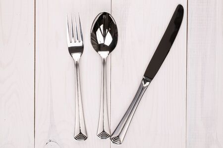 Spoon fork and knife on white wood