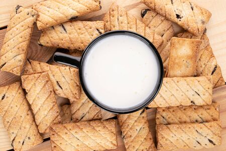 Lot of whole square puff cookie with raisins with cup of milkの写真素材