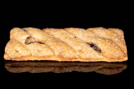 One whole square puff cookie with raisins isolated on black glassの写真素材