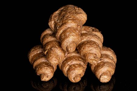 Lot of whole baked wholegrain croissant pyramid isolated on black glass