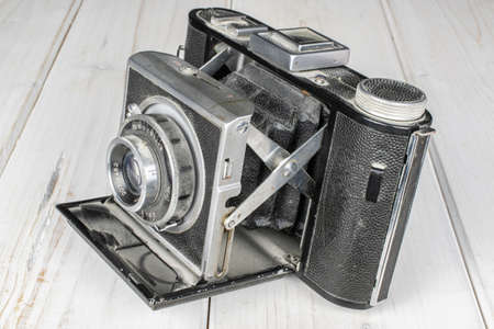 One whole opened vintage camera on white woodのeditorial素材