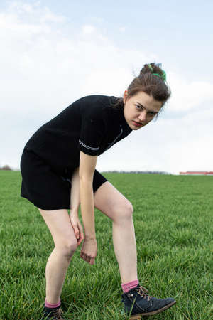 Impressive girl in black dress playing sport on green fieldの写真素材