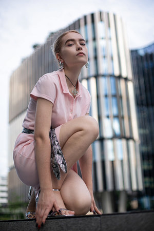 Young european girl with blonde hair outside in pinkの写真素材