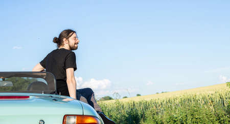 White european boy with dark hair outside sitting on the light carの写真素材