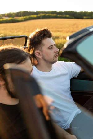 Young man with blonde hair in the car with friend