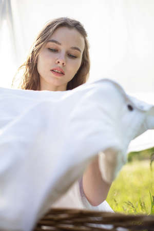 White woman with blonde hair portrait outside with white laundryの写真素材