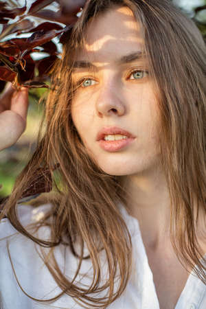 European woman in white clothes portrait outsideの写真素材