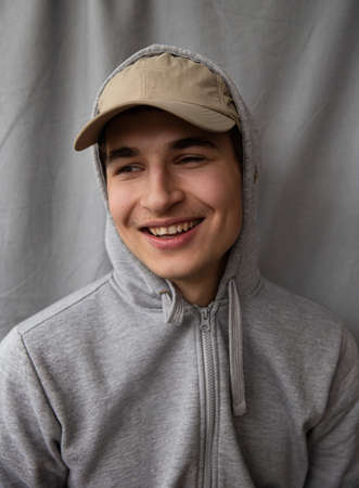 European white young man portrait isolated on gray in a sport capの写真素材