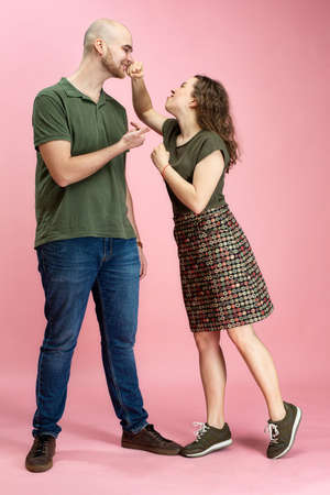 Happy white woman and man standing isolated on pink