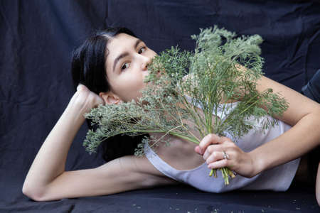 European white girl with a plant isolated on blackの写真素材
