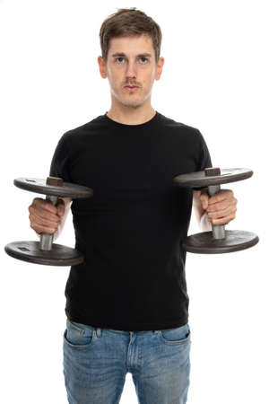 Young handsome tall slim white man with brown hair with dumbbells in black shirt in blue jeans isolated on white backgroundの写真素材