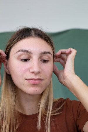 Portrait girl with hands near the face partially green background eyes are downの写真素材