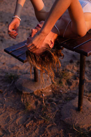 Lying white european woman with sand on background sunset lightの写真素材