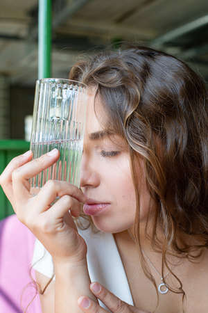 White european girl with glass near the face portraitの写真素材