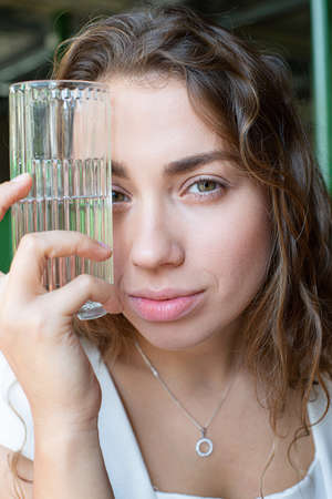 White european girl with glass near the face portraitの写真素材