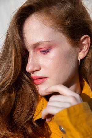 Portrait white girl with bright makeup near the wall portrait