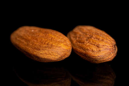 Group of two whole almond on black glass