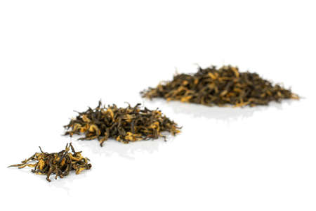 Dry black tea leaves in three groups isolated on white backgroundの写真素材