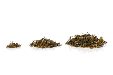 Dry black tea leaves in three groups isolated on white backgroundの写真素材