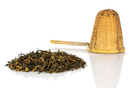 Dry black tea leaves with bamboo strainer isolated on white backgroundの写真素材