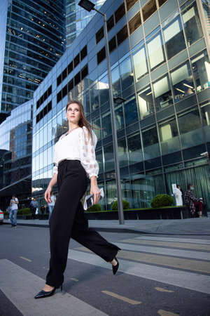 Walking young business woman on the street of a modern cityの写真素材