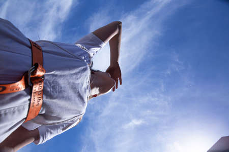 Looking up white european girl with long hair with sky behindの写真素材