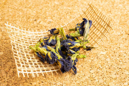 Lot of whole dry clitoria ternatea on natural sackcloth on cork surfaceの写真素材