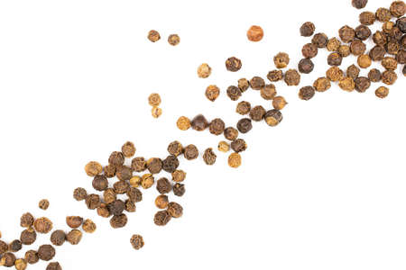 Lot of whole spicy black pepper isolated on white background placed diagonally