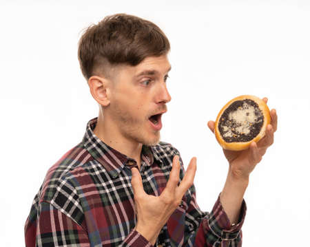 Young handsome tall slim white man with brown hair holding kolach mouth opened in flannel shirt...
