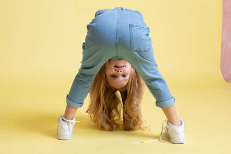 European baby girl with blonde hair isolated on yellow
