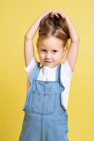 European baby girl with blonde hair isolated on yellowの写真素材