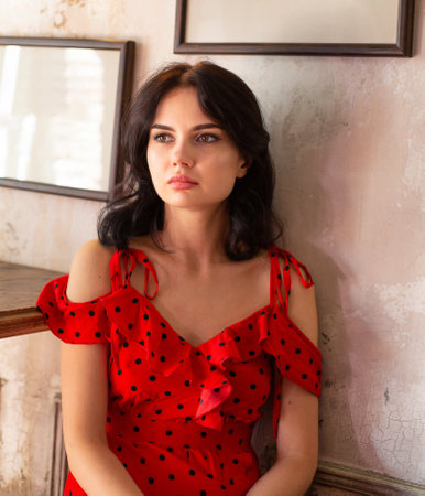 Portrait of young dark haired woman with white skin with pictures behindの写真素材