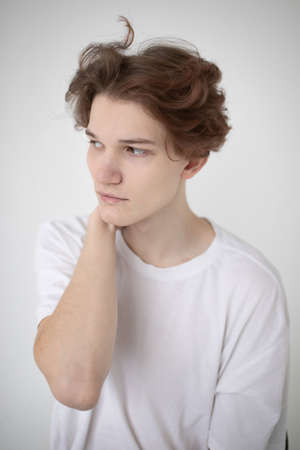 Portrait of attractive young european man in white shirt isolated on light greyの写真素材