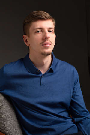 Attractive young blond european man with short beard and mustache isolated on black portraitの写真素材