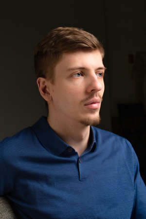 Attractive young blond european man with short beard and mustache isolated on black portraitの写真素材