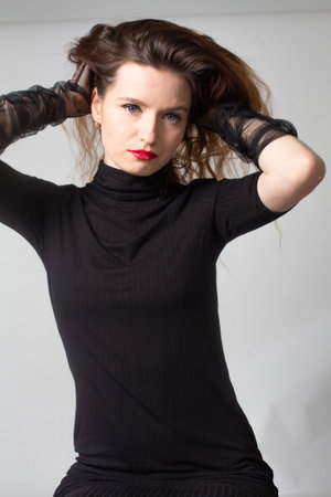 Slim white young european woman in total black isolated on greyの写真素材