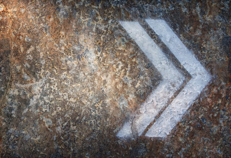 White Directional Arrow Painted on Stone Surface stock photoの写真素材