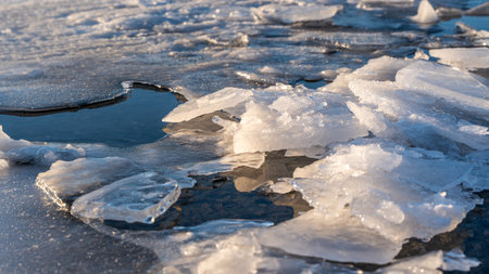 Frozen cracked lake ice with layers of transparent and white chunks